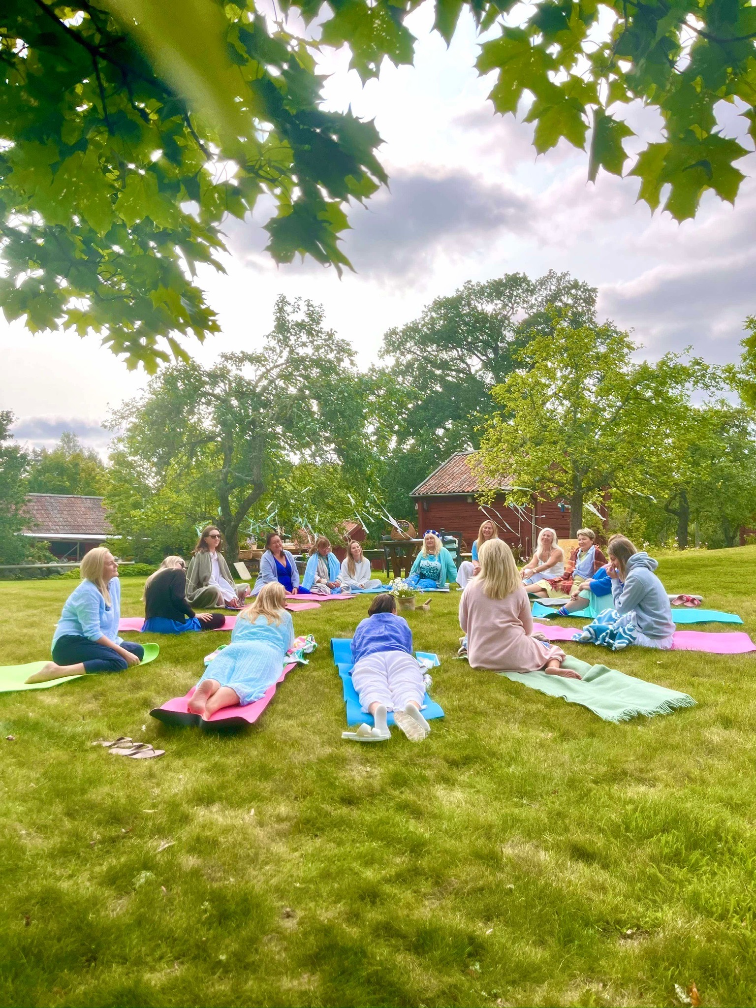 A retreat group practising together on a green lawn in Sweden