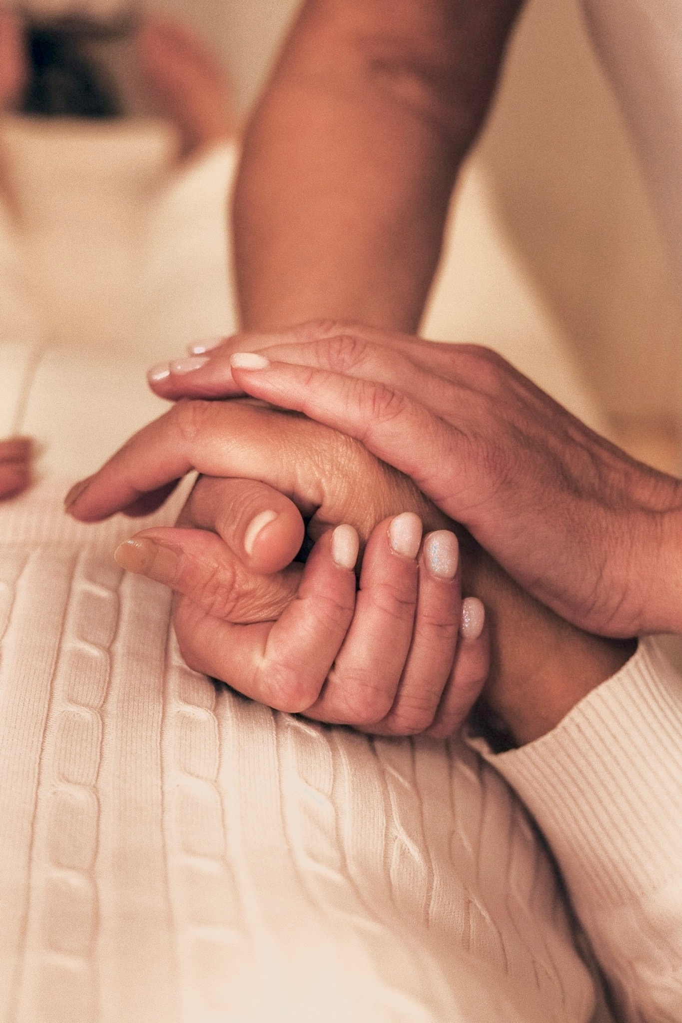 Lina gently holding a client’s hands during Reiki