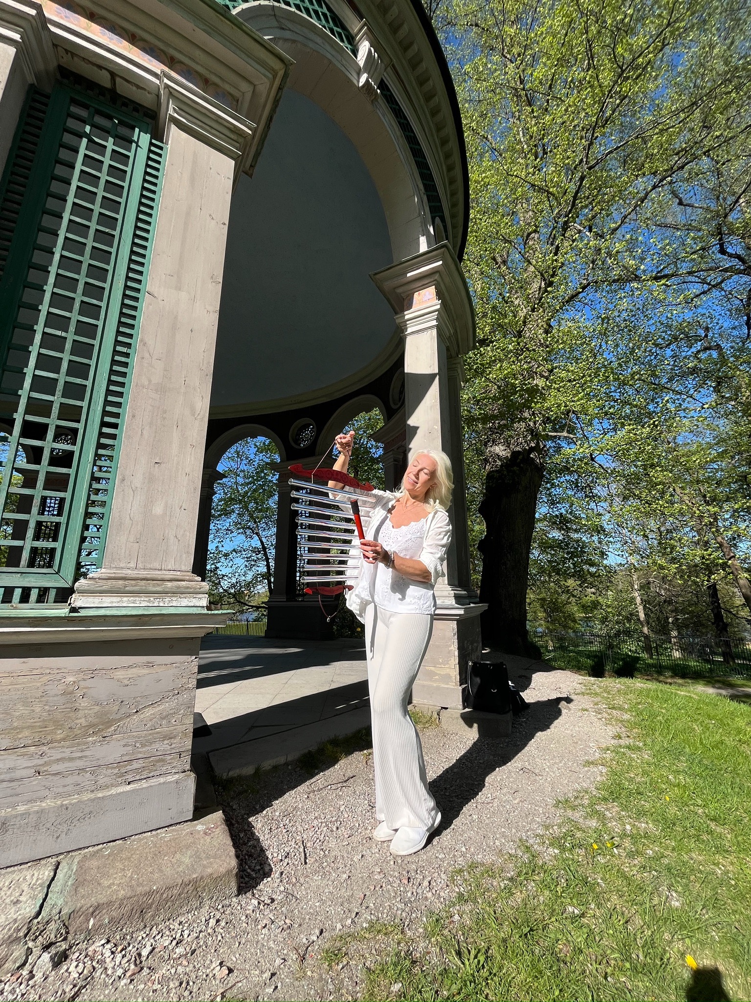Lina playing chimes in a natural setting